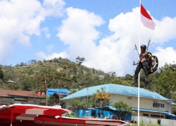 Personil Polres Tolikara Kibarkan Bendera Merah Putih Lewat Atraksi Paralayang