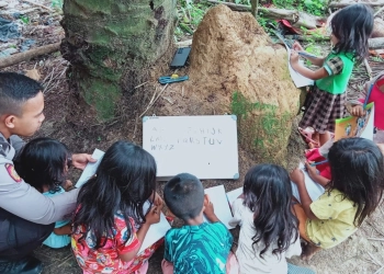 Dua Polisi Polda Jambi Ajarkan Membaca Anak Suku Anak Dalam Air Hitam